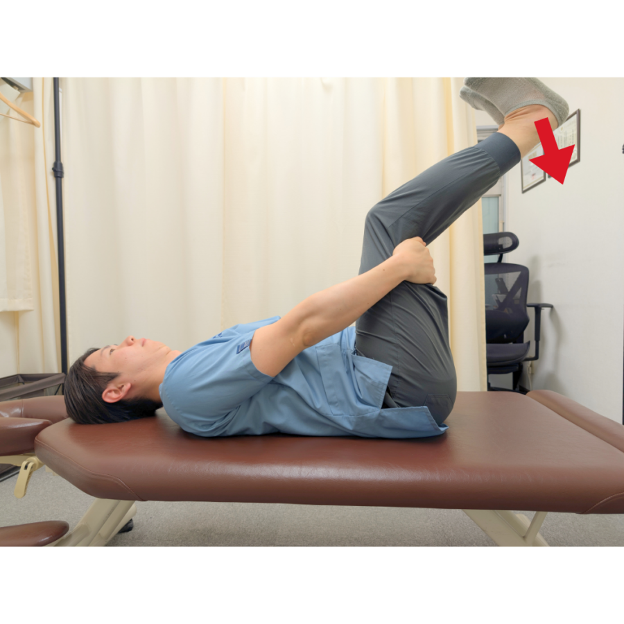 膝裏の位置を少し曲げ直し、最適なストレッチ角度（約1.5cm下げる）を調整している男性。